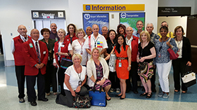 Large number of volunteers posing in front of an information booth.