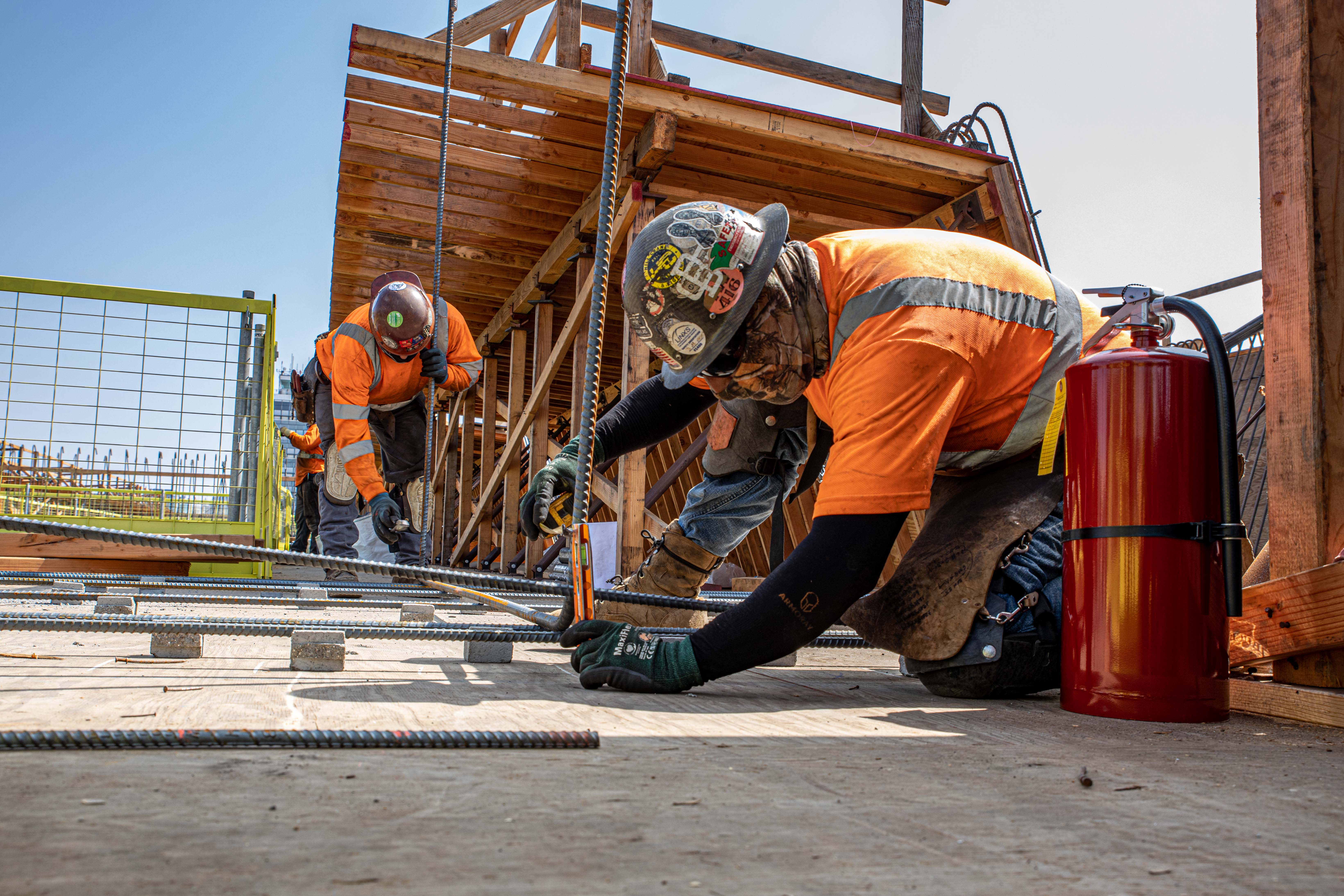 Crews work to install reinforcement bar in guideway formwork in advance of concrete placement.